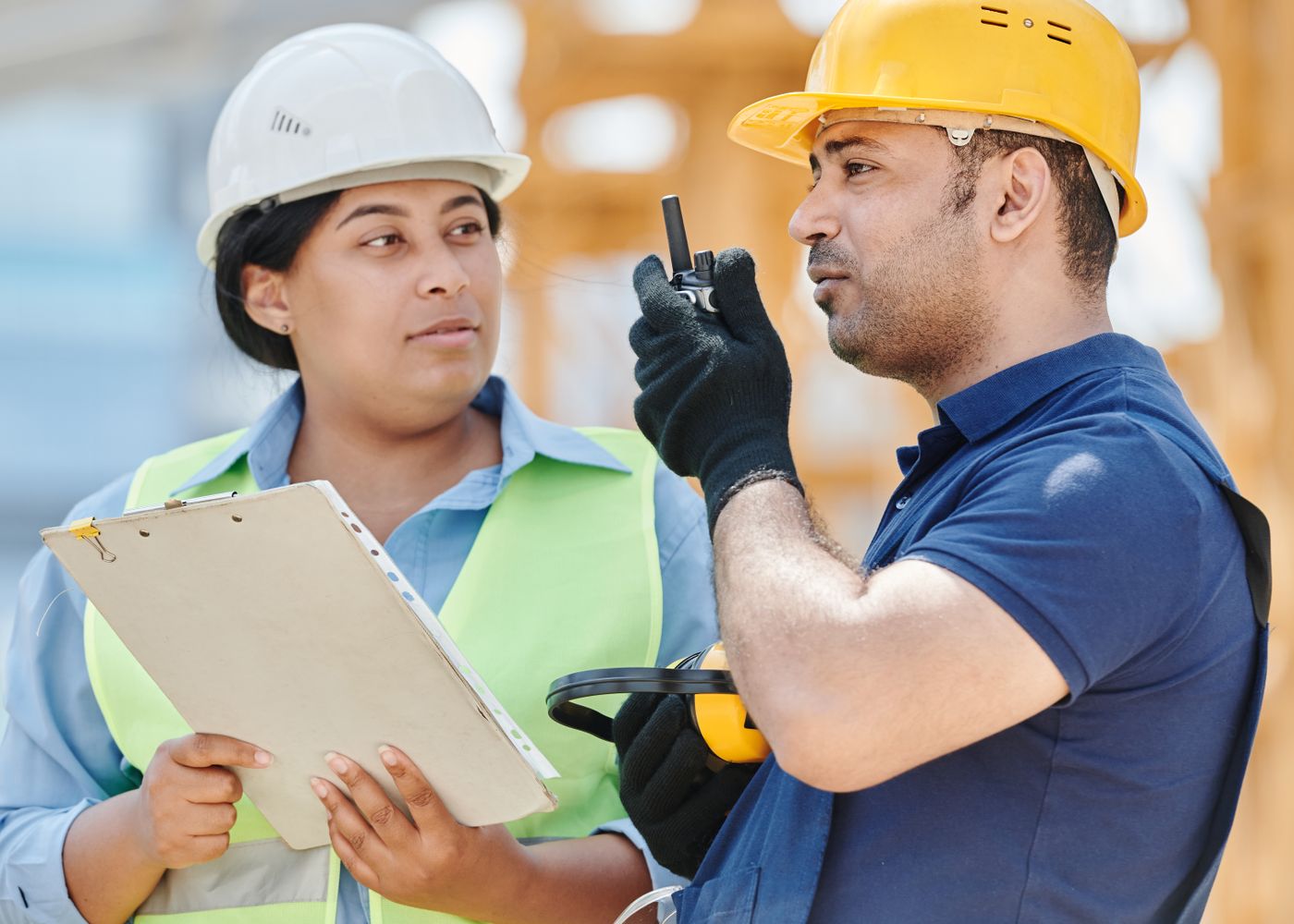 Site workers in hard hats and high-visibility clothing