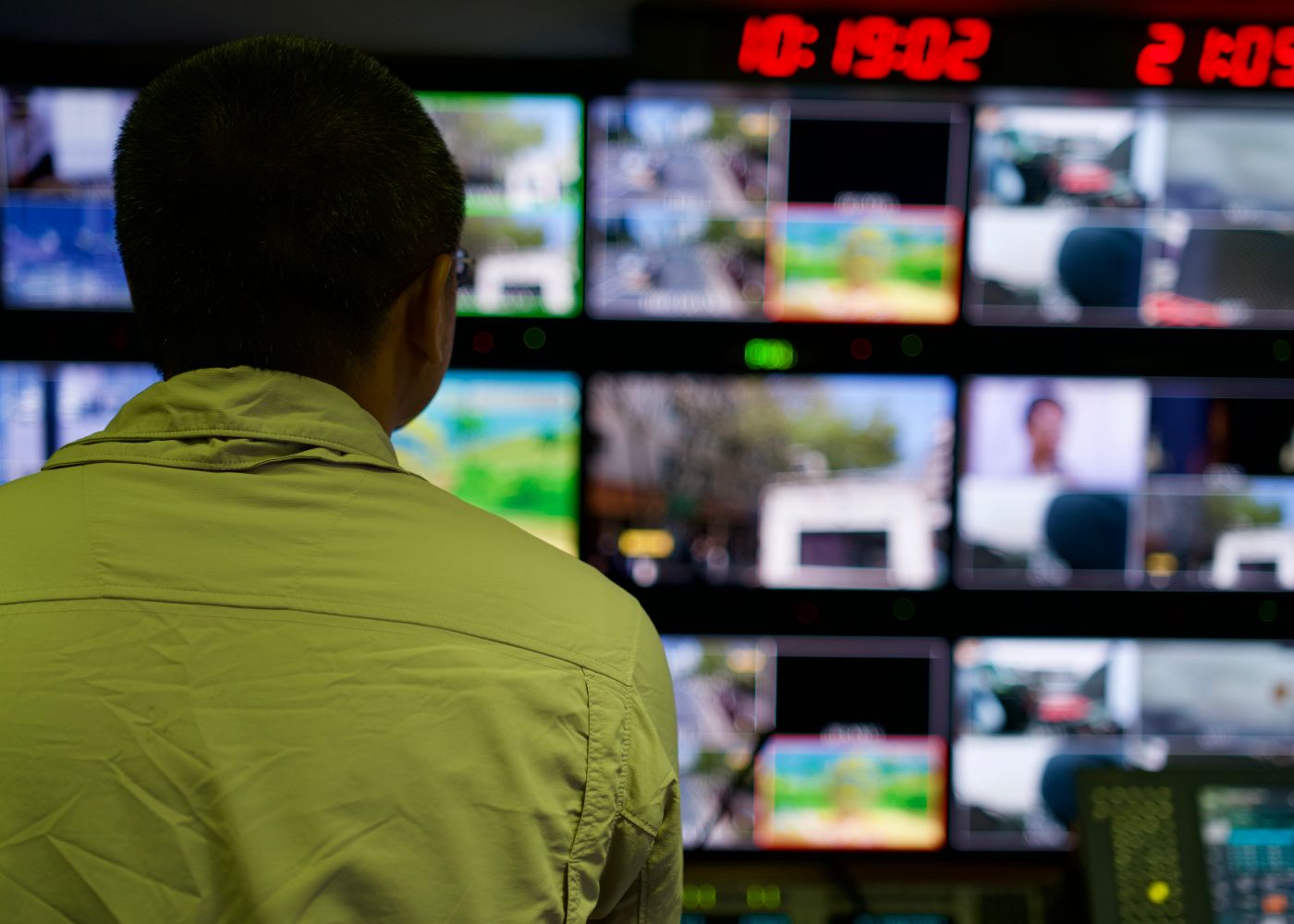 An operator monitoring alarm and CCTV screens in a control room