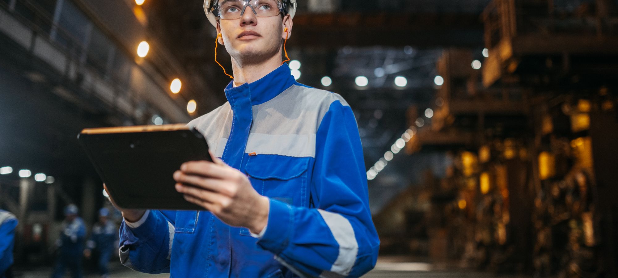 A quality engineer reviewing operations on a tablet